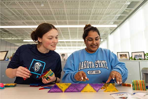 DSU CybHER student practicing activities with CybHER Director Kanthi Narukonda. 